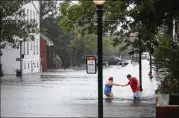  ?? CHIP SOMODEVILL­A / GETTY IMAGES ?? Shianne Coleman (left) gets a hand from friend Austin Gremmel as they walk the flooded streets of New Bern, N.C., as the Neuse River begins to flood its banks Friday during Hurricane Florence.