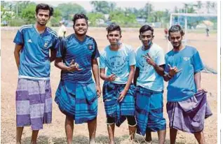  ??  ?? REMAJA India memakai kain pelekat ketika menyertai acara bola sepak.