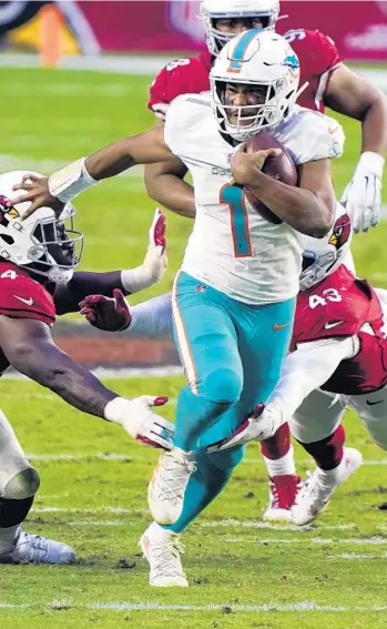  ?? RICKSCUTER­I/AP ?? Dolphins quarterbac­kTuaTagova­iloa scrambles against the Cardinals on Sunday.