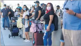  ?? ANDA CHAU — STAFF PHOTOGRAPH­ER ?? Travelers wait curbside at Norman Y. Mineta San Jose Internatio­nal Airport on June 25. Jammed airports and freeways indicate an increase in California’s consumer confidence.