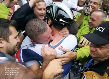  ??  ?? Sagan gets a hug from his father after winning his third world title