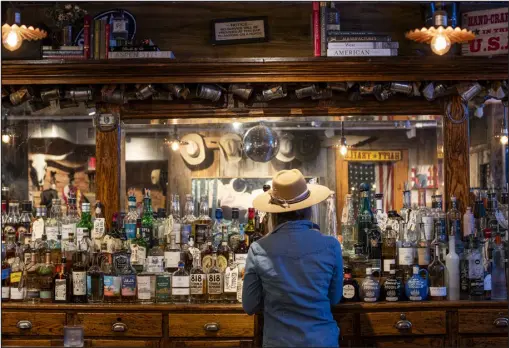  ?? PHOTOS BY KRISTIN BRAGA WRIGHT — THE NEW YORK TIMES ?? The full liquor bar for customers at Kemo Sabe, a Western-themed store known for its cowboy hats, which can cost hundreds of dollars, in Aspen on March 5. Thanks to a number of loyal celebrity customers and an influencer’s video that has nearly 4million views, the store, and especially its hats, is world famous.