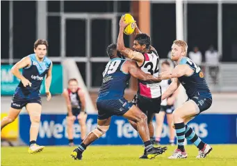  ?? Picture: MICHAEL FRANCHI ?? Southern Districts’ Charles McAdam is gang tackled by Darwin’s Cameron Stokes and Todd Miles last night at TIO Stadium