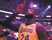  ?? Kelvin Kuo / Associated Press ?? The Lakers’ LeBron James points to the rafters in tribute to the late Lakers star, Kobe Bryant.