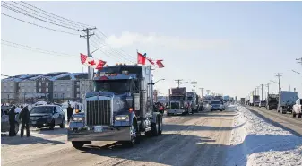  ?? DAVID LIPNOWSKI, THE CANADIAN PRESS ?? Supporters of Canadian truck drivers protesting the COVID-19 vaccine mandate cheer on a convoy of trucks on their way to Ottawa on the Trans-Canada Highway west of Winnipeg, Man., on Tuesday.