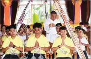  ?? SAKCHAI LALIT ?? Soccer coach Ekkapol Janthawong, second from left, and members of the rescued soccer team attend a Buddhist ceremony that is believed to extend the lives of its attendees as well as ridding them of dangers and misfortune­s in Mae Sai district, Chiang...