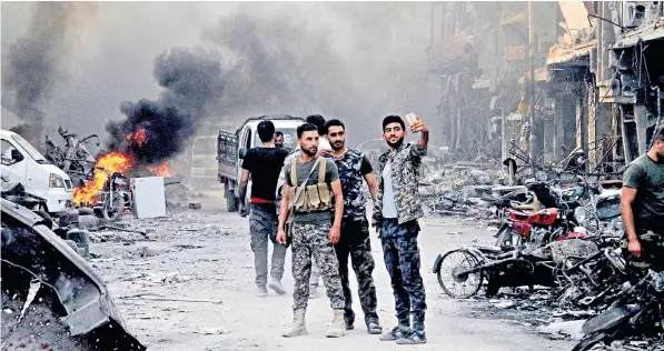  ??  ?? Syrian soldiers celebratin­g in the Hajar al-aswad district, south of Damascus, hours after it was declared free of Isil fighters. The battle to drive out the jihadists has claimed the lives of thousands of civilians