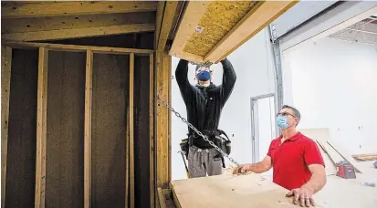  ?? JULIE JOCSAK TORSTAR ?? Teacher Dino Nardangeli supervises Ryan Ward at the Niagara Catholic District School Board’s Launch Centre in Welland as he works on a vendor booth for an outdoor Christmas market to be held over six weekends in downtown Niagara Falls.