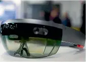  ?? AP ?? Members of a design team, left, demonstrat­e use of Microsoft’s HoloLens device, above. The US Army has awarded Microsoft a US$480 million contract to supply its HoloLens headsets to soldiers.