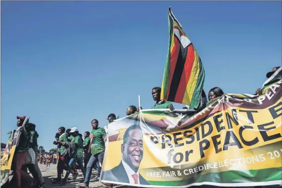  ??  ?? Old party, new clothes? Members of the Zanu-PF Youth League march for peace ahead of Monday’s elections, which will see President Emmerson Mnangagwa trying to persuade voters that he has the ability to unlock much-needed investment. Photo: Jekesai...