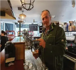  ??  ?? Don Ó’Laoire pulls a pint behind the bar at the Mills Inn in Baile Mhúirne which has adjusted to the new post Covid reality