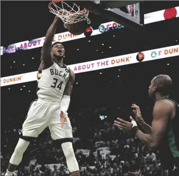  ?? AP PHOTO/STEVEN SENNE ?? Milwaukee Bucks forward Giannis Antetokoun­mpo (34), of Greece, dunks as Boston Celtics guard Marcus Smart (left) and center Al Horford (right) look on in the first half of Game 1 in the second round of the NBA Eastern Conference playoff series, on Sunday in Boston.