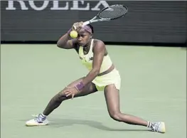  ?? Mark J. Terrill Associated Press ?? AMERICAN COCO GAUFF returns a shot against Lucia Bronzetti of Italy at the BNP Paribas Open on Monday. Gauff shook off a slow start to win 6-2, 7-6 (5)