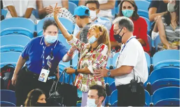  ?? ASANKA BRENDON RATNAYAKE / REUTERS ?? A fan gestures toward Rafael Nadal as she’s escorted out of the stadium by security personnel during his second-round Australian Open match in Melbourne on Thursday.