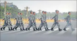  ?? AP ?? Chinese military personnel walk across a street next to Tiananmen Square in Beijing on April 29.