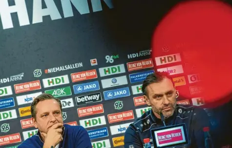  ?? Foto:christophe Gateau/dpa ?? Finstere Mienen in Hannover: Sportdirek­tor Horst Heldt (links) und Trainer Thomas Doll wissen, wie schwer die Aufgabe beim FC Augsburg wird.