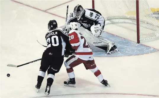  ?? PETER RUICCI/SAULT STAR/POSTMEDIA NETWORK ?? Petes defenceman Declan Chisholm, left, tries to keep Greyhounds winger Kalvyn Watson away from a rebound off Hunter Jones on Sunday in Sault Ste. Marie.