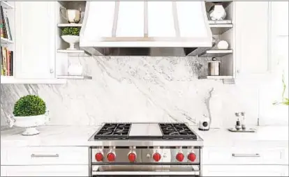  ??  ?? Slab backsplash­es, such as this one using a piece of marble, have a clean, refined look. Slabs are usually more expensive but will eliminate the need to maintain the grout. GETTY IMAGES