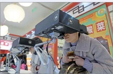  ?? PROVIDED TO CHINA DAILY PROVIDED TO CHINA DAILY ?? Visitors wear 3D virtual reality headsets at a VRthemed restaurant in Shanghai on Sunday. In the restaurant where dishes are prepared for enjoyment Visitors wear 3-D virtual reality headsets at a VR-themed restaurant in Shanghai on Sunday. In the...