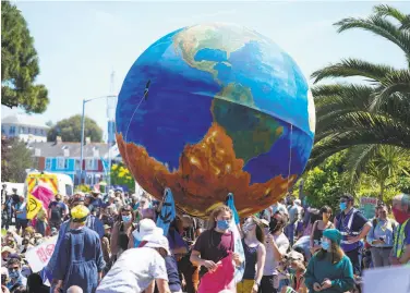  ?? Hugh Hastings / Getty Images ?? Protesters in Falmouth, England, demand more aggressive action to stem global warming. The protest took place as leaders of the globe’s largest economies were gathered in the county for the G7 summit.