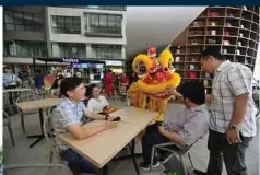  ??  ?? Guests being greeted by a lion dance performanc­e outside Tea Live outlet and BookXcess instagramm­able shelves.