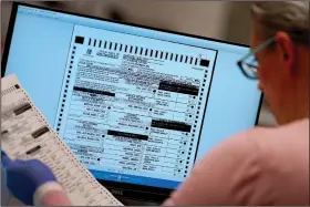  ?? (File Photo/AP/Matt York) ?? An election worker verifies a ballot on a screen Nov. 10 inside the Maricopa County Recorders Office in Phoenix. Stories circulatin­g online incorrectl­y claim Arizona’s Maricopa County announced that more than 540,000 voters visited voting centers on Election Day and that only 248,000 Election Day ballots were counted; therefore, the county “lost” some 292,000 votes.