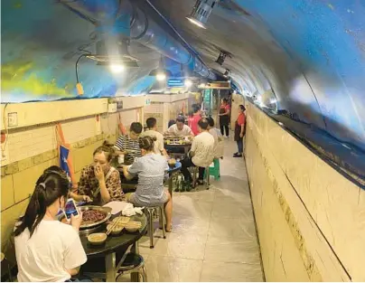  ?? MARK SCHIEFELBE­IN/AP ?? Escaping a heat wave, diners eat hotpot in the cool of a converted WWII air raid shelter Aug. 20 in Chongqing, China.