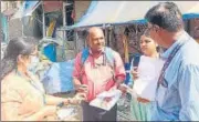  ?? HT PHOTO ?? BMC’s community mobiliser Vinod Rathod (pink shirt) discusses list of patients with WHO officials.