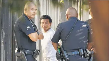  ?? Photograph­s by Al Seib Los Angeles Times ?? POLICE ARREST a suspect in connection with a fire that damaged two apartment buildings under constructi­on Monday in East Hollywood. It was reported about 6 a.m. in the 400 block of North Heliotrope Drive.