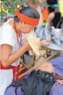  ?? JIM THOMPSON/JOURNAL ?? Roberta Trujillo, a curandera, blows a conch shell as she finishes a sobadas at a traditiona­l health fair on UNM’s campus on Wednesday afternoon.