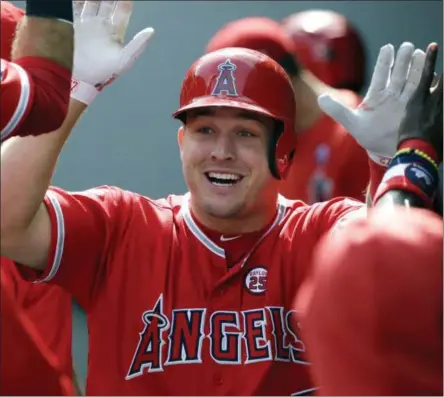 ?? TED S. WARREN - THE ASSOCIATED PRESS ?? FILE - In this Sept. 10, 2017, file photo, Los Angeles Angels’ Mike Trout is greeted in the dugout after hitting a solo home run in the first inning of a baseball game against the Seattle Mariners in Seattle.
