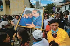 ?? ARIANA CUBILLOS/AP ?? Supporters of President Gustavo Petro display a painting of him and Vice President Francia Marquez before the swearing-in ceremony Sunday in Bogota, Colombia.