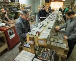  ?? RICK MADONIK/TORONTO STAR PHOTOS ?? A steady stream of customers make their way through the stacks at Vortex Records. Store founder and owner Bert Myers is closing it after nearly four decades.
