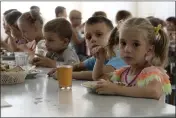  ?? THE ASSOCIATED PRESS ?? Children from an orphanage in the Donetsk region of Ukraine eat a meal at a camp in Zolotaya Kosa, a settlement on the Sea of Azov, Rostov region, southweste­rn Russia, on July 8.