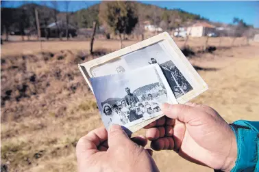  ?? EDDIE MOORE/JOURNAL ?? Guadalupit­a resident Donald Laran shows a photo of his First Communion group from when the village’s church still stood.