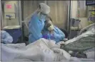  ?? AP FILE ?? Romelia Navarro, right, is comforted by nurse Michele Younkin as she weeps while sitting at the bedside of her dying husband, Antonio, in the COVID-19 unit at St. Jude Medical Center in Fullerton, Calif., on July 31.