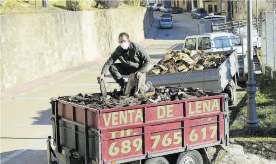  ?? TONI GUDIEL ?? Faustino Martín El leñador, encima de su remolque lleno de madera, sostiene varios troncos.