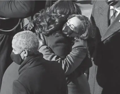  ?? PHOTOS BY WILLIAM BRETZGER/USA TODAY ?? Michelle Obama and Kamala Harris, right, embrace as President Barack Obama and Douglas Emhoff stand by following the inaugurati­on ceremony at the U.S. Capitol on Wednesday in Washington.