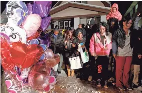  ?? PAT A. ROBINSON / MILWAUKEE JOURNAL SENTINEL ?? Family and friends hold a candleligh­t vigil Tuesday for Melanie Johnson, 15, who died Monday night when gunfire struck her home on N. 35th St. near W. Silver Spring Drive.