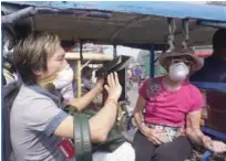  ?? Agence Franece-presse ?? Internatio­nal tourists wear masks to protect against air pollution as they travel in an electric rickshaw in the old quarters of New Delhi on Monday.