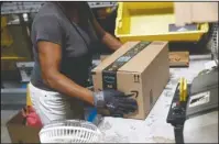  ?? The Associated Press ?? RAISE: Myrtice Harris applies tape to a package before shipment at an Amazon fulfillmen­t center on Aug. 3, 2017, in Baltimore. Amazon is boosting its minimum wage for all U.S. workers to $15 per hour starting next month. The company said Tuesday that the wage hike will benefit more than 350,000 workers, which includes full-time, part-time, temporary and seasonal positions.