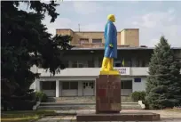  ?? Foto Gleb Garanich/Reuters ?? V barve ukrajinske zastave odet kip Vladimirja Lenina sredi nemirne regije Doneck