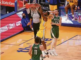  ?? CARY EDMONDSON/USA TODAY SPORTS ?? Warriors forward Andrew Wiggins (22) dunks the ball in front of Bucks guard Pat Connaughto­n (24) on Tuesday.