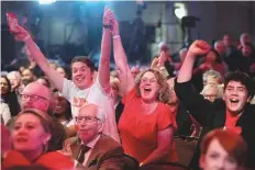  ?? AP ?? New Zealand Labour Party supporters react as results are shown on a screen at a party event after the polls closed in Auckland, New Zealand, yesterday.