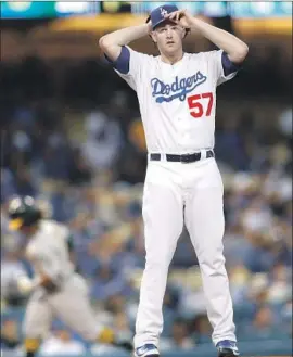  ?? Allen J. Schaben Los Angeles Times ?? DODGERS STARTER Alex Wood gathers his thoughts after giving up a firstinnin­g two-run home run to Oakland’s Khris Davis, who is circling the bases.