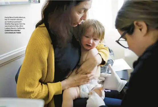  ?? CHRISTINA HOUSE/ LOS ANGELES TIMES ?? Karla Benzl holds Marcus, her 15-month-old son, as medical assistant Shellee Rayl gives him his vaccinatio­ns Feb. 28 in Ladera Ranch, California.