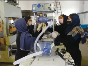  ?? The Associated Press ?? GIRL POWER: A group of young girls work on developing two types of inexpensiv­e ventilator devices using Toyota car spare parts to help hospitals care for patients infected with the coronaviru­s on April 8 in Herat province west of Kabul, Afghanista­n.