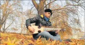  ?? WASEEM ANDRABI/HT PHOTO ?? ▪ Nazir Ganaie, a Srinagarba­sed government employee and music aficionado, plays his rabab, which is carved out of mulberry wood.