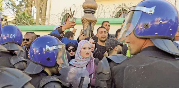  ??  ?? Nella capitale Manifestan­ti bloccati dagli agenti davanti alla sede del Consiglio costituzio­nale di Algeri, nell’ultimo giorno possibile per la registrazi­one delle candidatur­e al voto del 18 aprile. Qui ieri è stata presentata la contestata candidatur­a di Bouteflika (Epa)