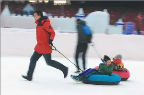  ?? CHENG GONG / FOR CHINA DAILY ?? Parents and their children enjoy ice-based recreation­al activities at Bird’s Nest, or the National Stadium, on Dec 23.